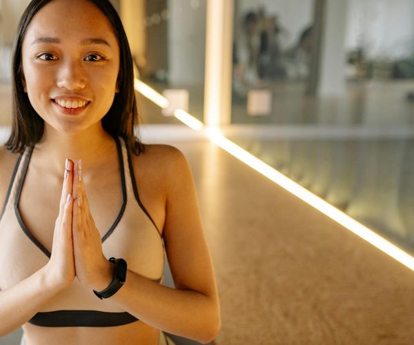Smiling woman in sportswear sitting peacefully after a workout.